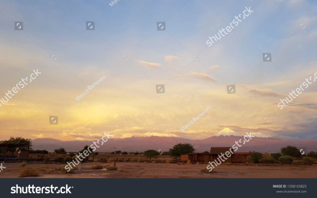 Sunset lights in the arid and desolate landscape of the Atacama desert with the tops of the snowy volcanoes of the Andes mountain range in the background. Author and Copyright Marco Ramerini
